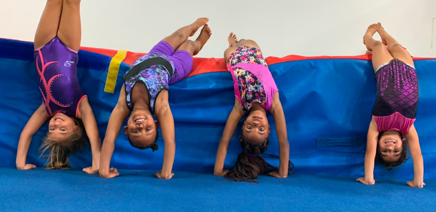 Four girls doing hand stands