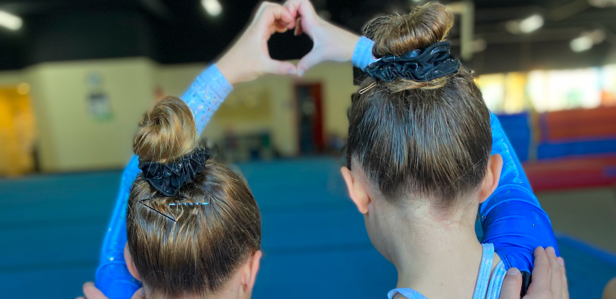 Two girls creating a heart with their hands