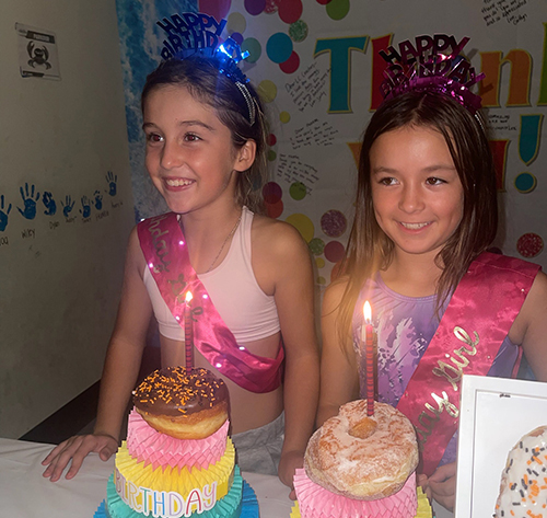 Two birthday girls wearing party hats