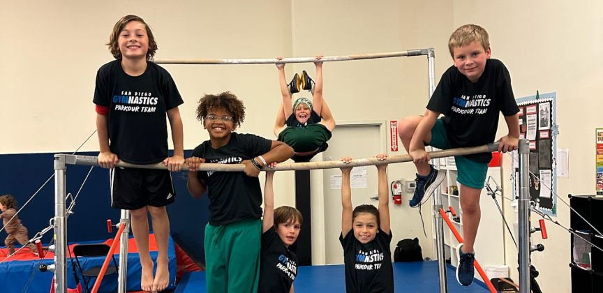 Kids balancing on a gymnastics bar