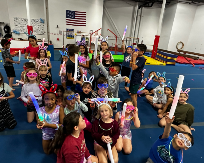 A group of kids wearing bunny ears and sun glasses posing together for a picture