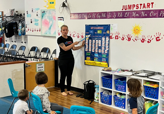 A jumpstart teacher showing a calendar to her students