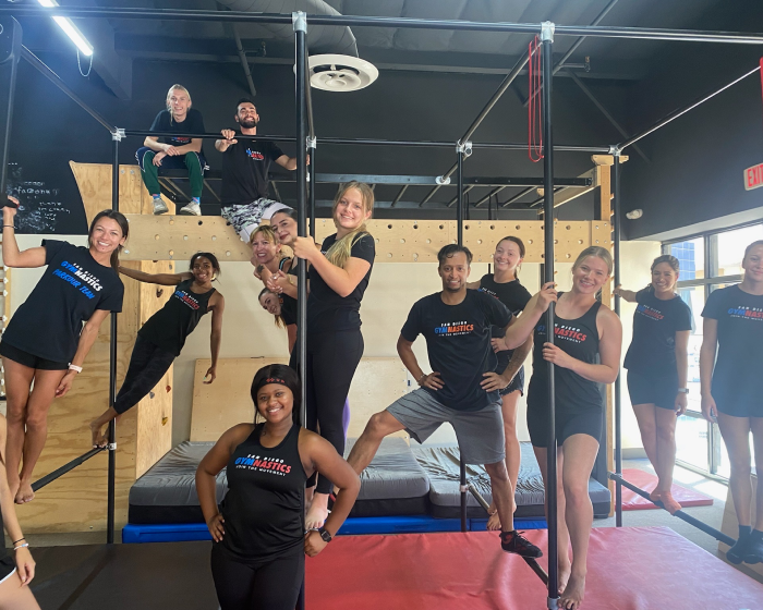 The SD Gym team posing together balancing on gymnastics parkour equipment