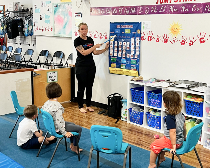 A teacher showing a calendar to her students