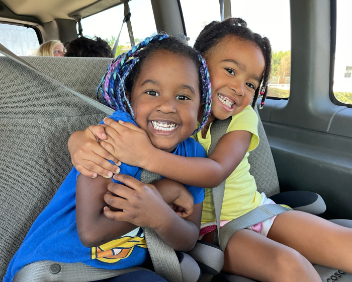 Two kids traveling in an S.D. Gym bus together