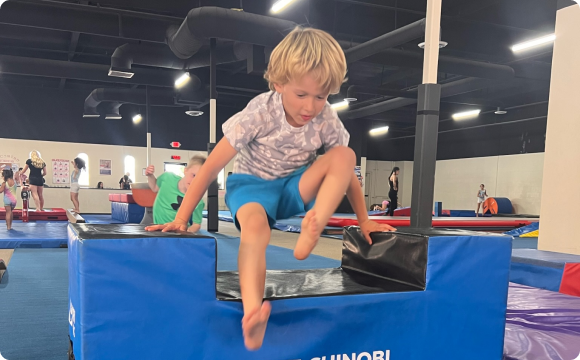 A boy leaping over a ledge