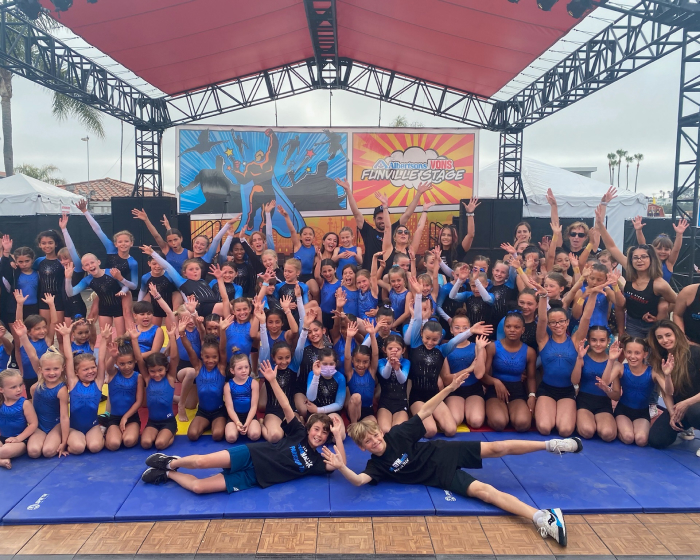 A large group of kids and instructors together at the Del Mar fair posing for a pic