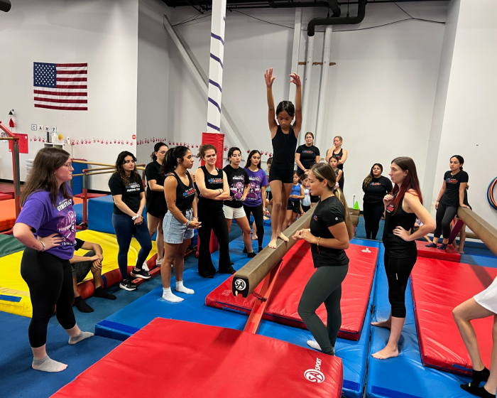 Instructors helping a student on a balancing exercise