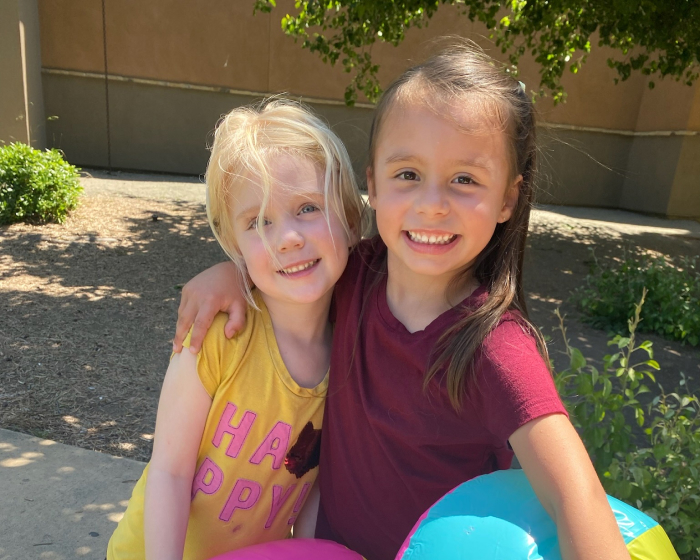 Two girls posing with arms around each other