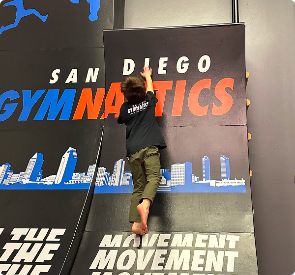 A boy running up the side of a ramp.